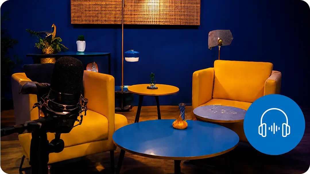 Estudio de grabación del podcast Talks de MindUp Academy con sillones amarillos, micrófono e ícono de audio